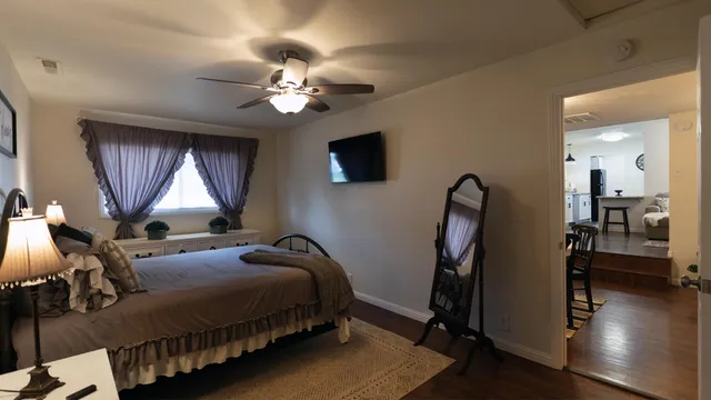 a spacious bedroom with a bed and wooden floor