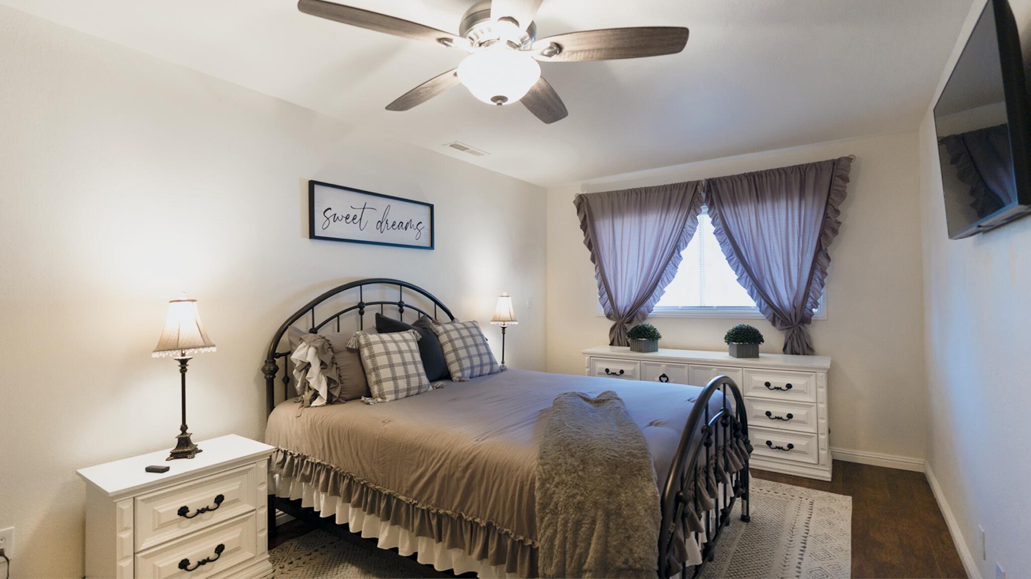 20577 Sunset Lane Redding, CA 96002 - Photo 20 of 29 a bedroom with a bed a flat tv screen and a dresser