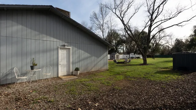 a view of a house with backyard and tree