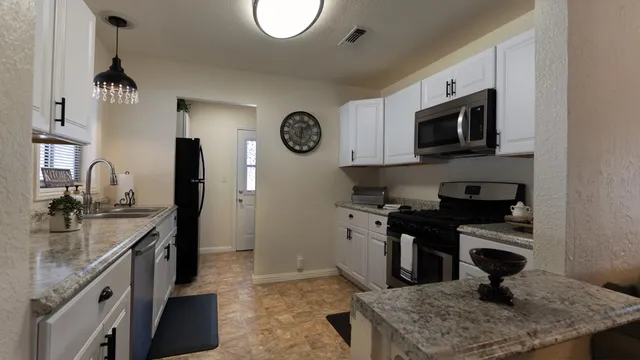 a kitchen with stainless steel appliances granite countertop a sink stove and refrigerator