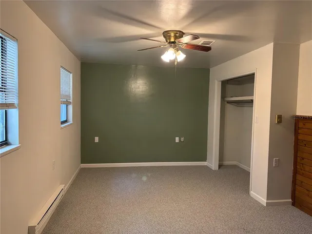 a view of an empty room with a chandelier fan