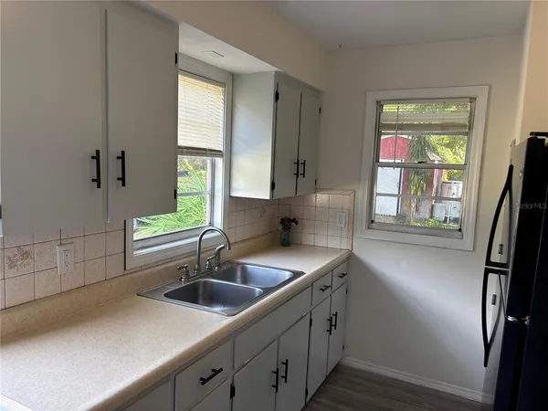 a kitchen with stainless steel appliances a sink a window and wooden floor