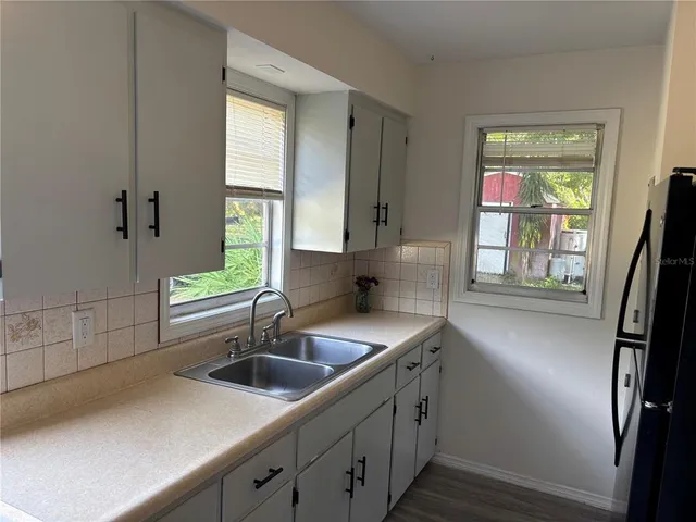 a kitchen with stainless steel appliances a sink a window and wooden floor