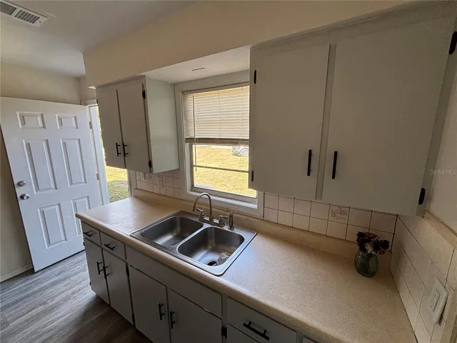 a kitchen with a sink appliances and cabinets