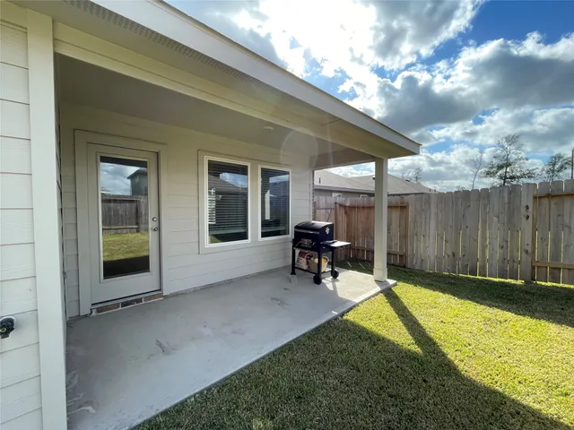 a view of backyard with a chair and table in the patio