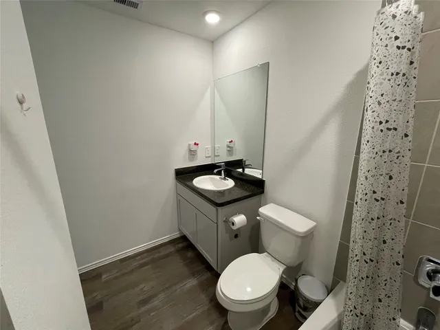 a bathroom with a granite countertop toilet a sink and a mirror