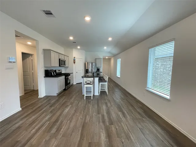 a view of kitchen with wooden floor and electronic appliances