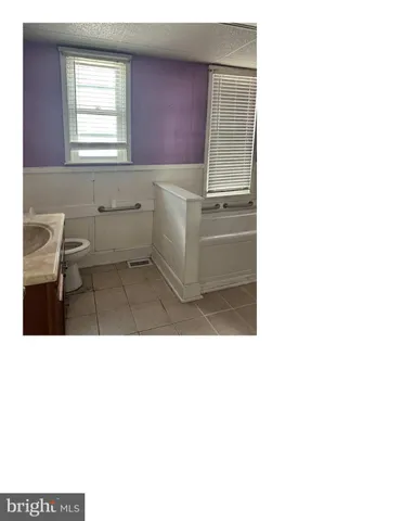 a bathroom with a sink a toilet and a window