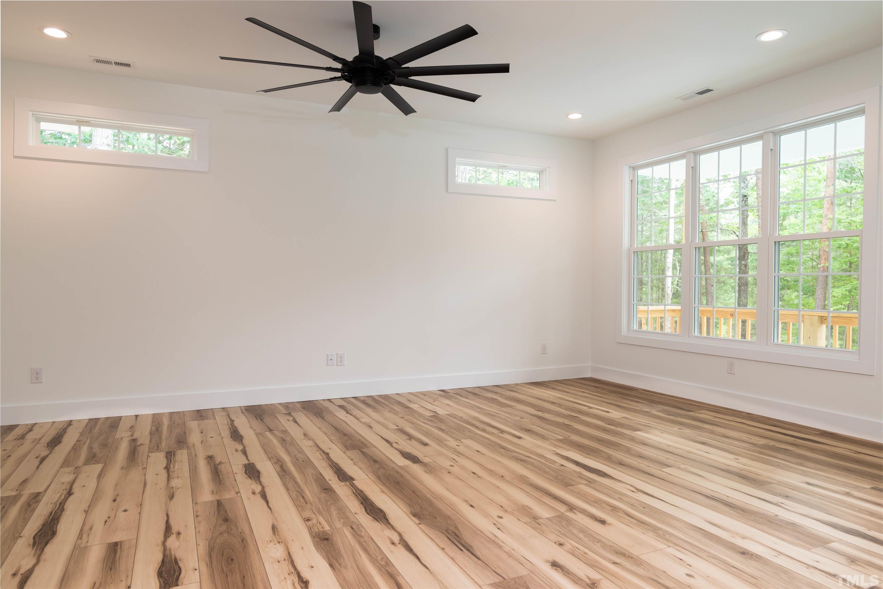 3602 Moriah Road Rougemont, NC 27572 - Photo 5 of 26 an empty room with wooden floor fan and windows