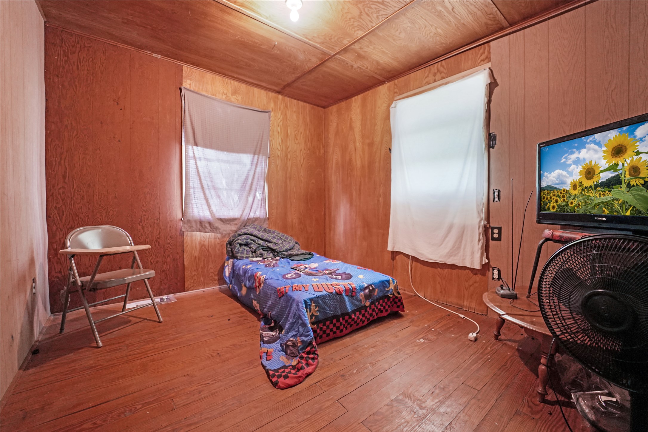 691 County Road 1333 Liberty, TX 77575 - Photo 13 of 24 a bedroom with a bed and a chair with the wooden floor