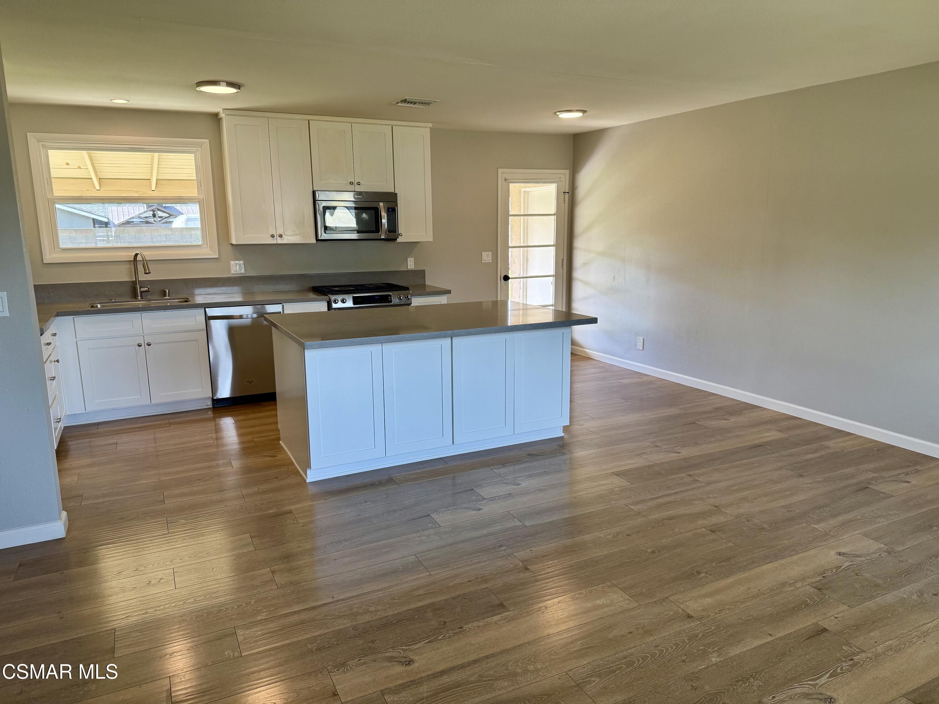 4090 Florence Street Simi Valley, CA 93063 - Photo 4 of 16 a kitchen with granite countertop a stove a sink and a microwave