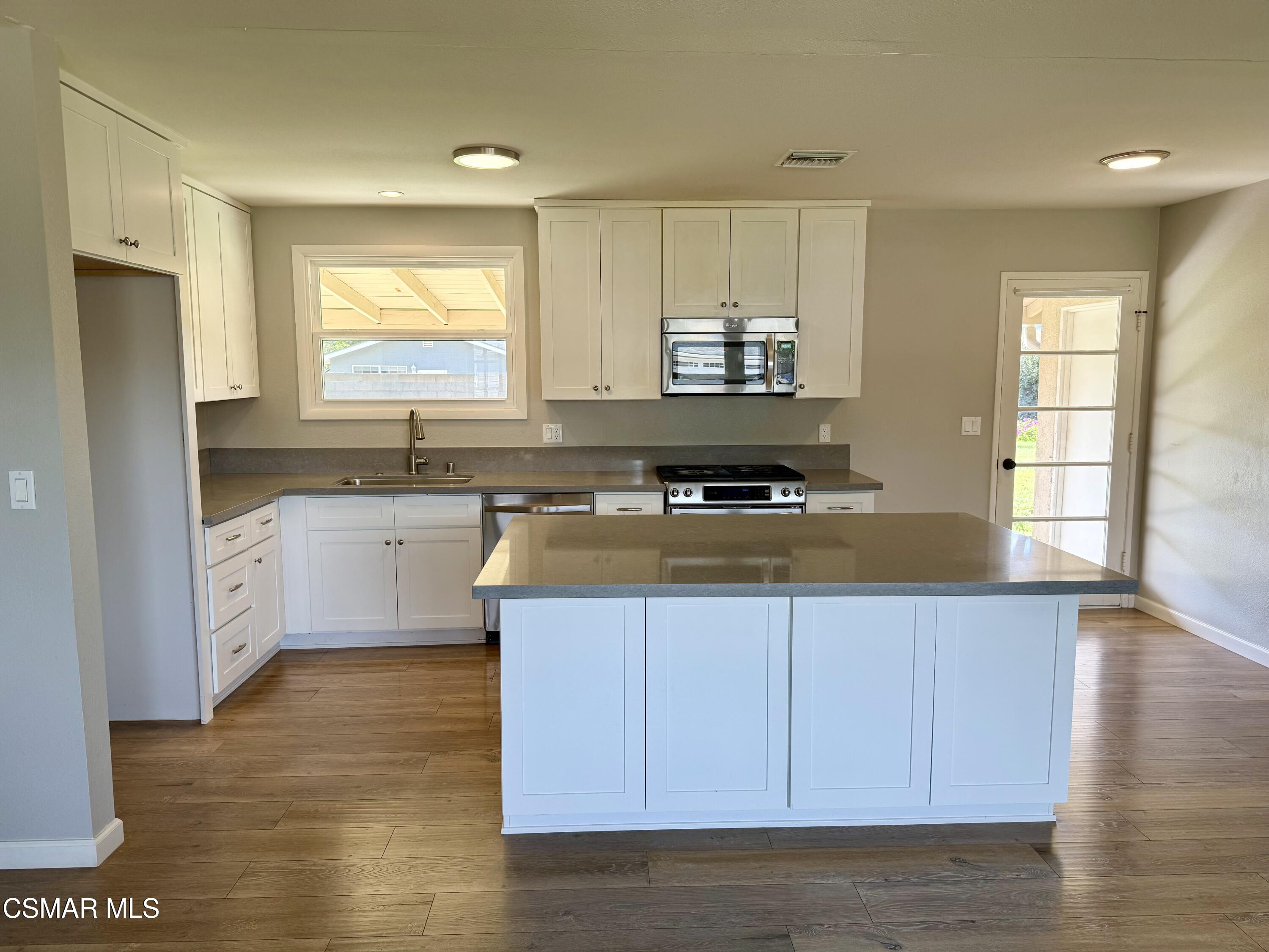 4090 Florence Street Simi Valley, CA 93063 - Photo 5 of 16 a kitchen with stainless steel appliances a sink a stove a refrigerator cabinets and a window