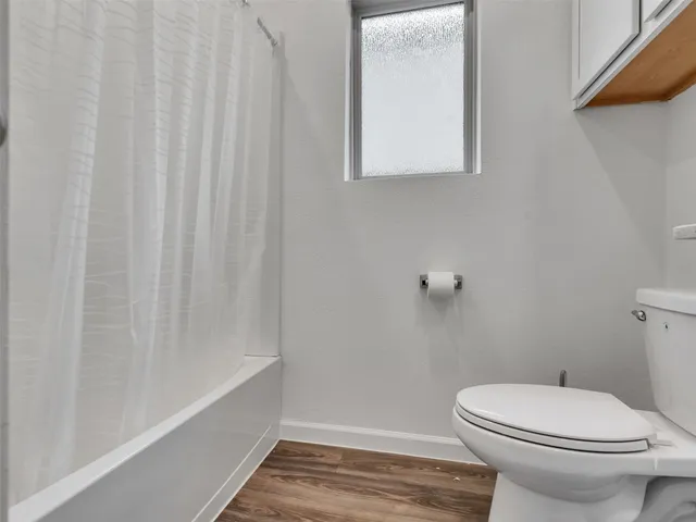 a bathroom with a toilet and a shower curtain
