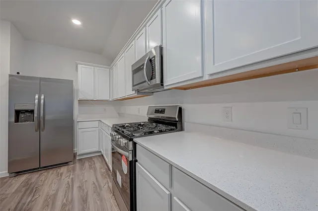 a kitchen with stainless steel appliances white cabinets and a stove