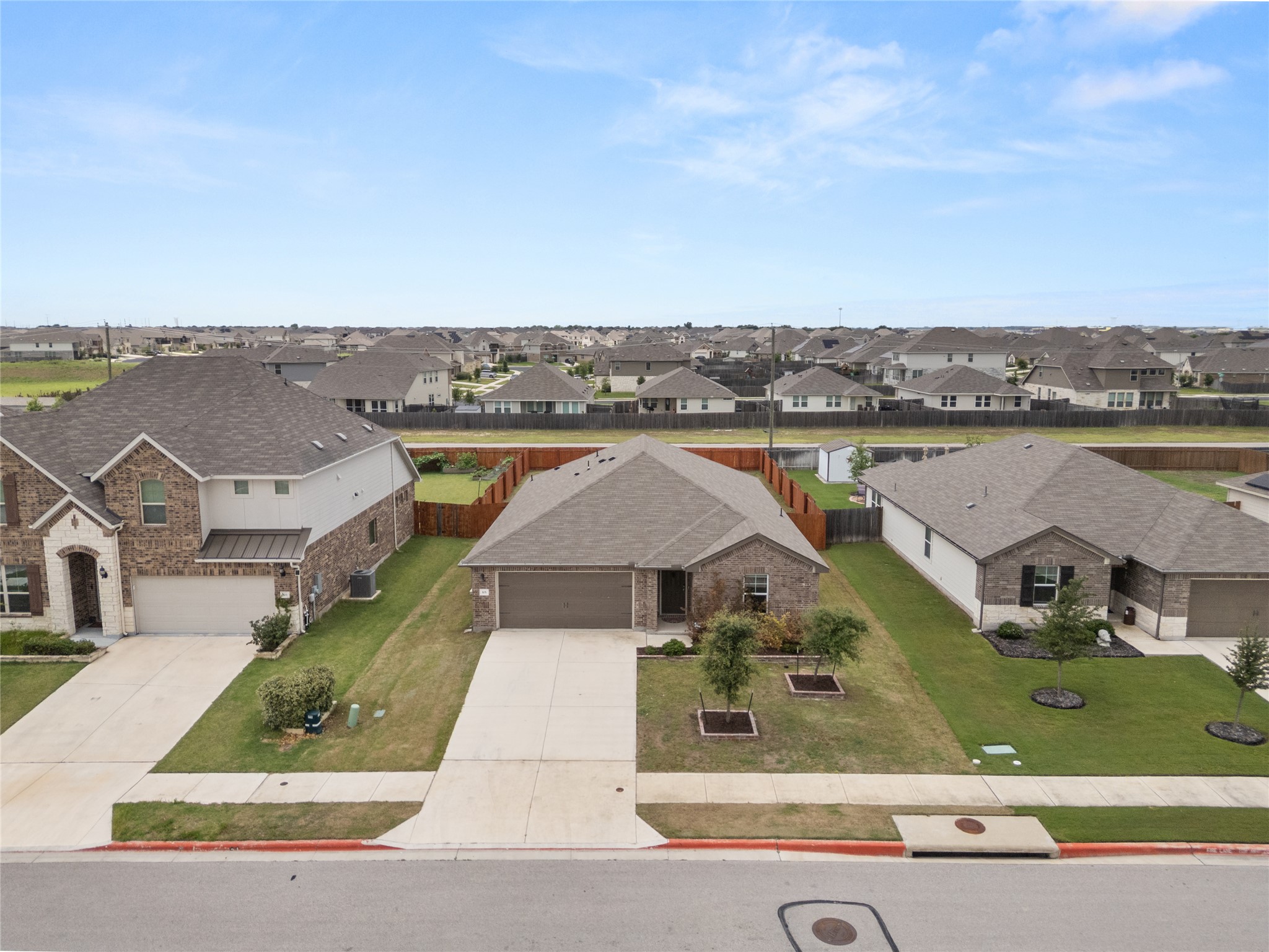 105 Saviano Road Hutto, TX 78634 - Photo 21 of 22 Discover a welcoming neighborhood with tidy homes and ample green spaces under a wide-open sky.