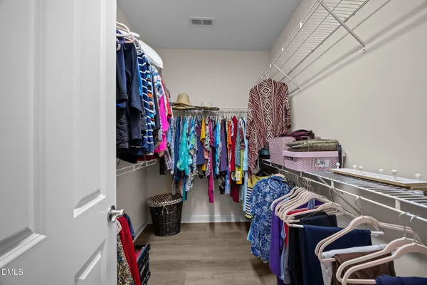a view of walk in closet with clothes