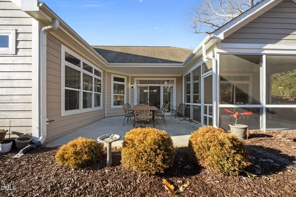 a view of a house with backyard and sitting area