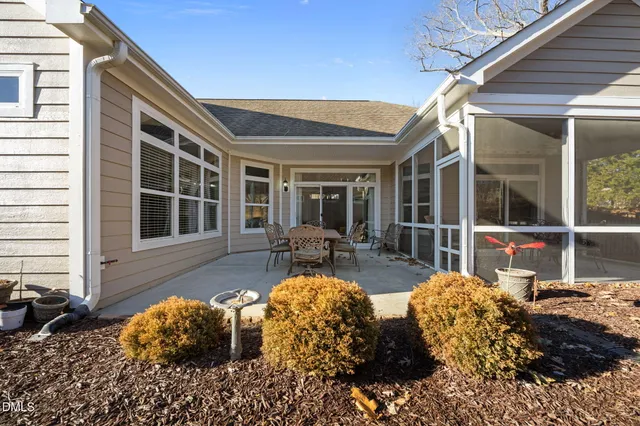 a view of a house with backyard and sitting area