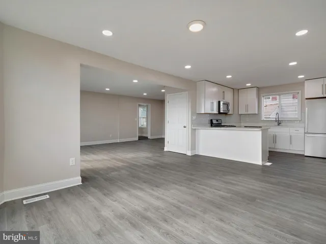 a kitchen with a refrigerator a stove top oven and a center island with wooden floor