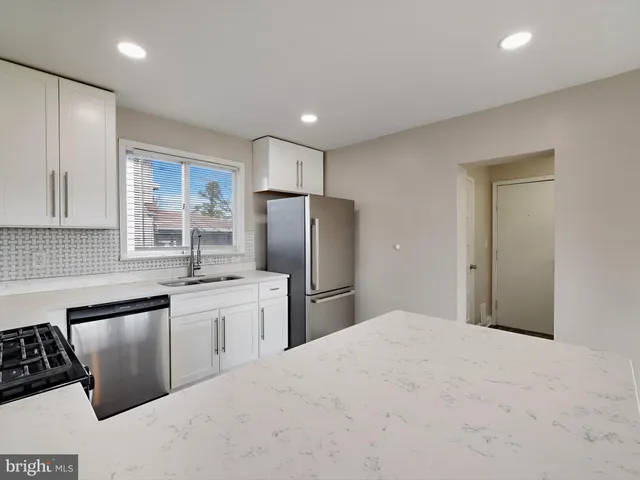 a kitchen with granite countertop a stove a sink and a microwave
