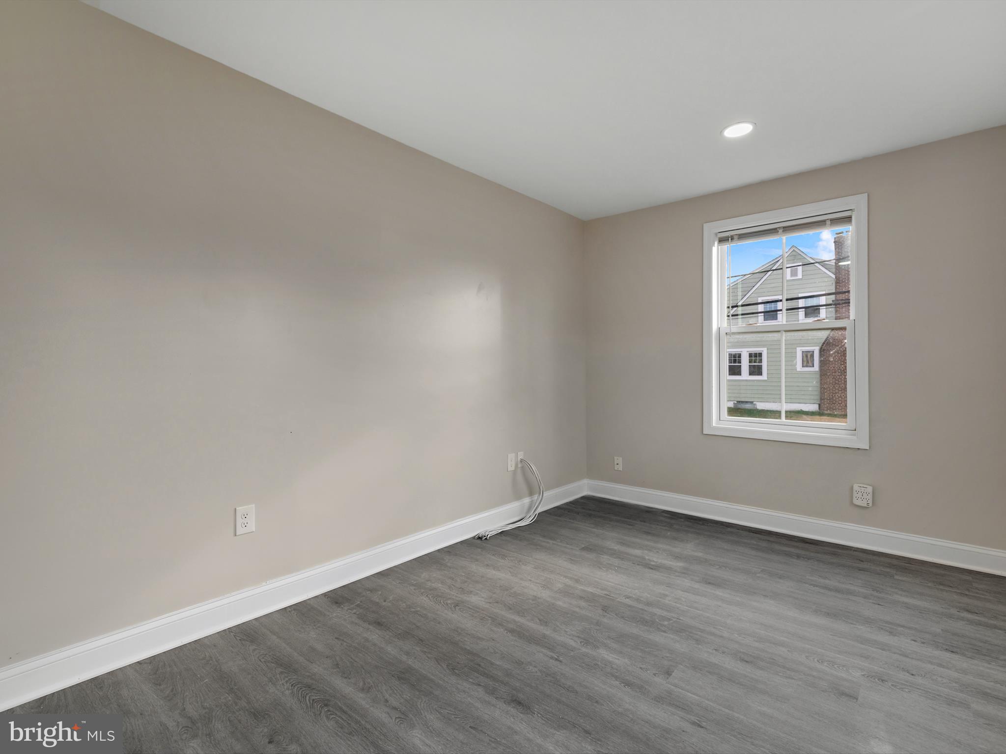 4129 5th Street Baltimore, MD 21225 - Photo 18 of 52 a view of an empty room with wooden floor and a window