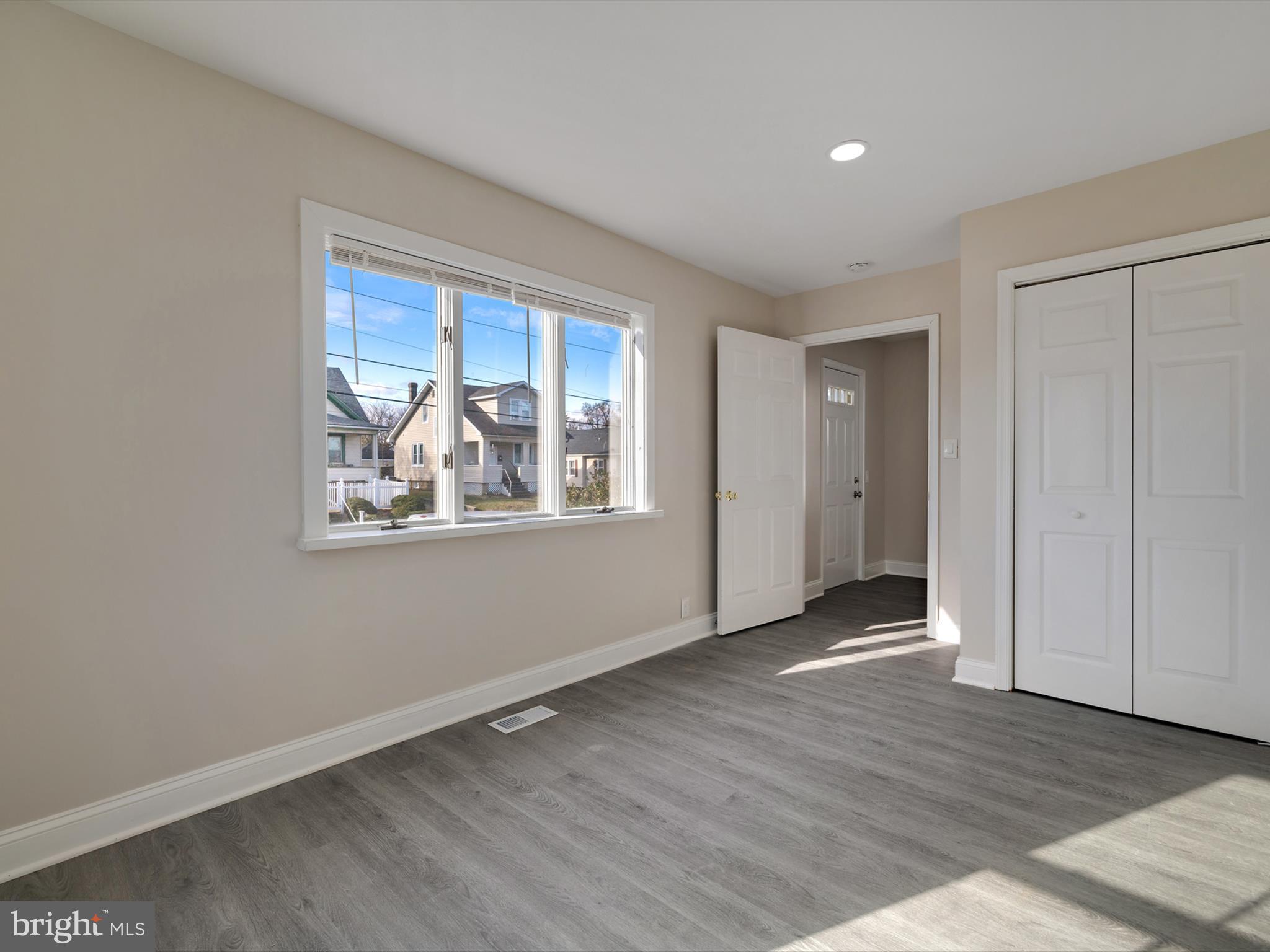 4129 5th Street Baltimore, MD 21225 - Photo 19 of 52 an empty room with wooden floor and windows