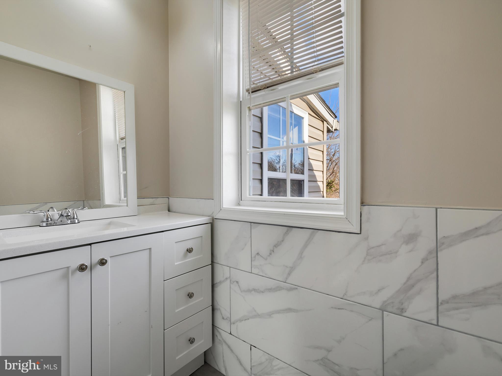 4129 5th Street Baltimore, MD 21225 - Photo 23 of 52 a bathroom with a granite countertop sink and a window