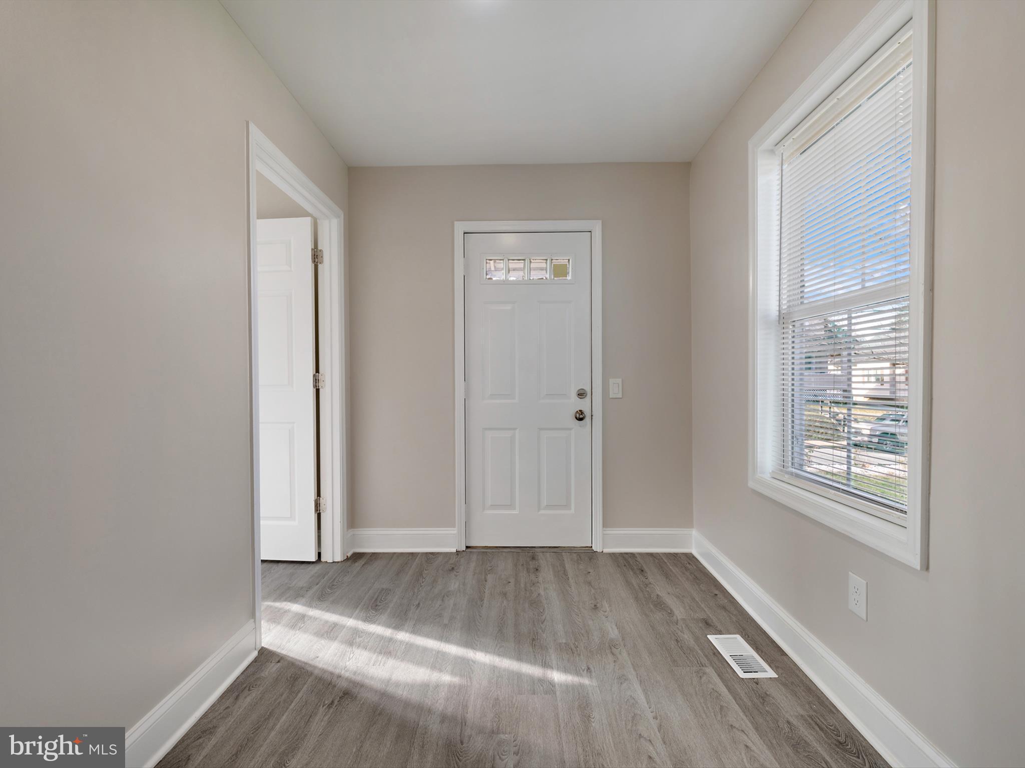 4129 5th Street Baltimore, MD 21225 - Photo 3 of 52 an empty room with wooden floor and windows