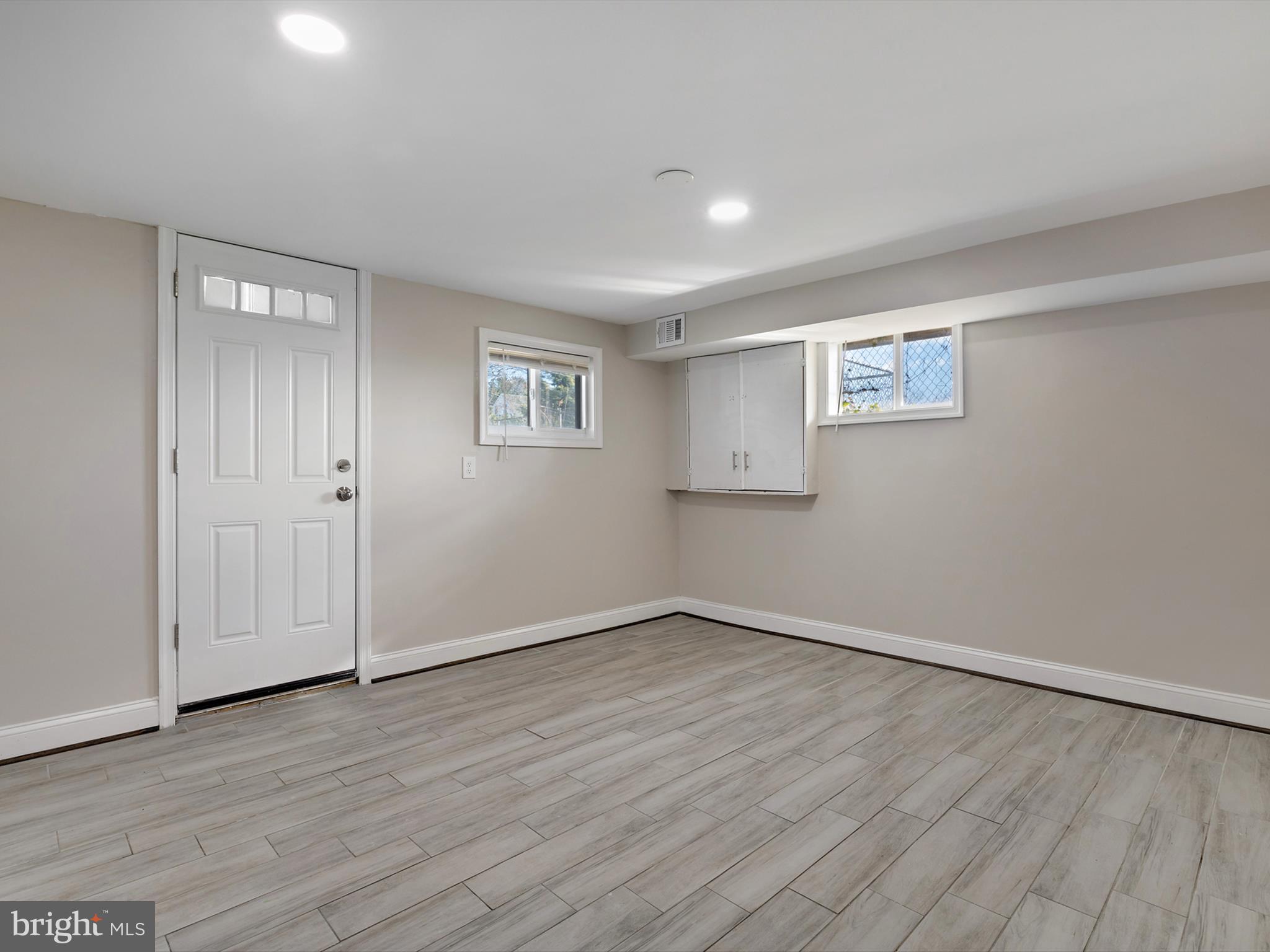 4129 5th Street Baltimore, MD 21225 - Photo 39 of 52 an empty room with wooden floor and windows