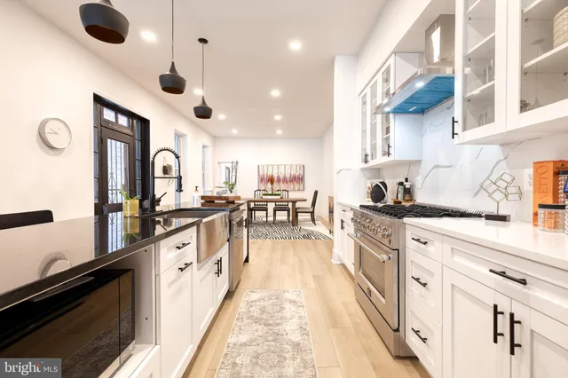 a large kitchen with stainless steel appliances granite countertop a lot of counter space and a sink