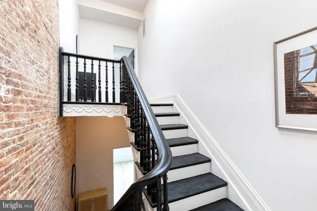 a view of a hallway with a dining area with a bathroom