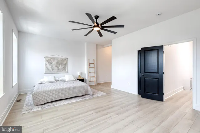 a kitchen with stainless steel appliances kitchen island a table chairs in it and wooden floors