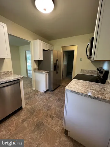 a view of a kitchen with a sink and dishwasher a stove top oven with wooden floor