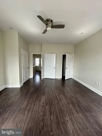 a view of empty room with wooden floor and ceiling fan