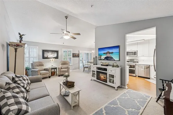 a living room with furniture a flat screen tv and a stove
