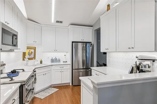 a kitchen with appliances a sink and cabinets