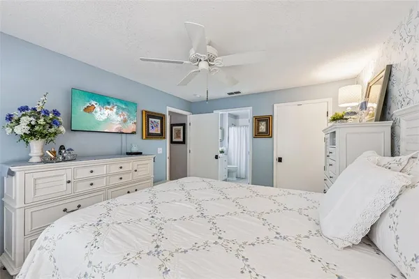 a bedroom with a large bed and a flat screen tv