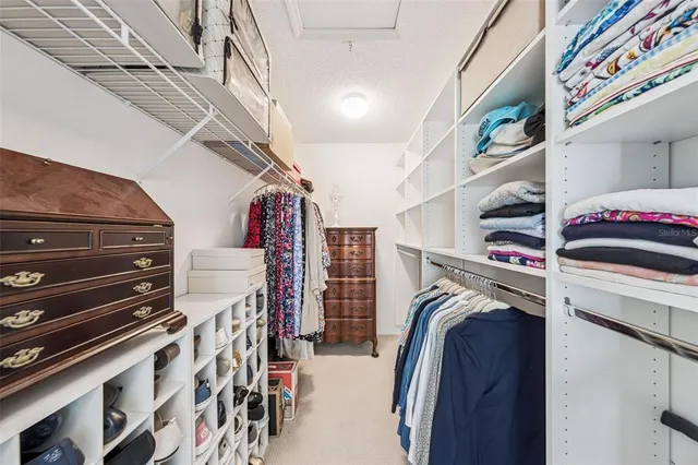 a view of walk in closet with clothes and shoes