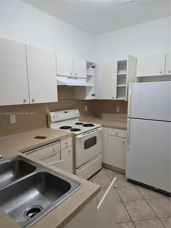 a kitchen with a sink appliances and cabinets