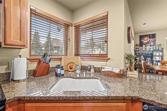 an outdoor kitchen with granite countertop a sink and a counter top space