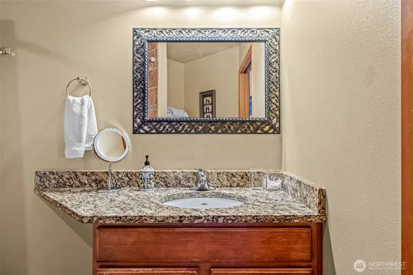 a bathroom with a granite countertop sink and a mirror