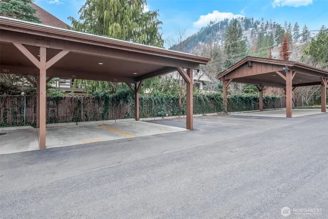 a backyard of a house with table and chairs under an umbrella