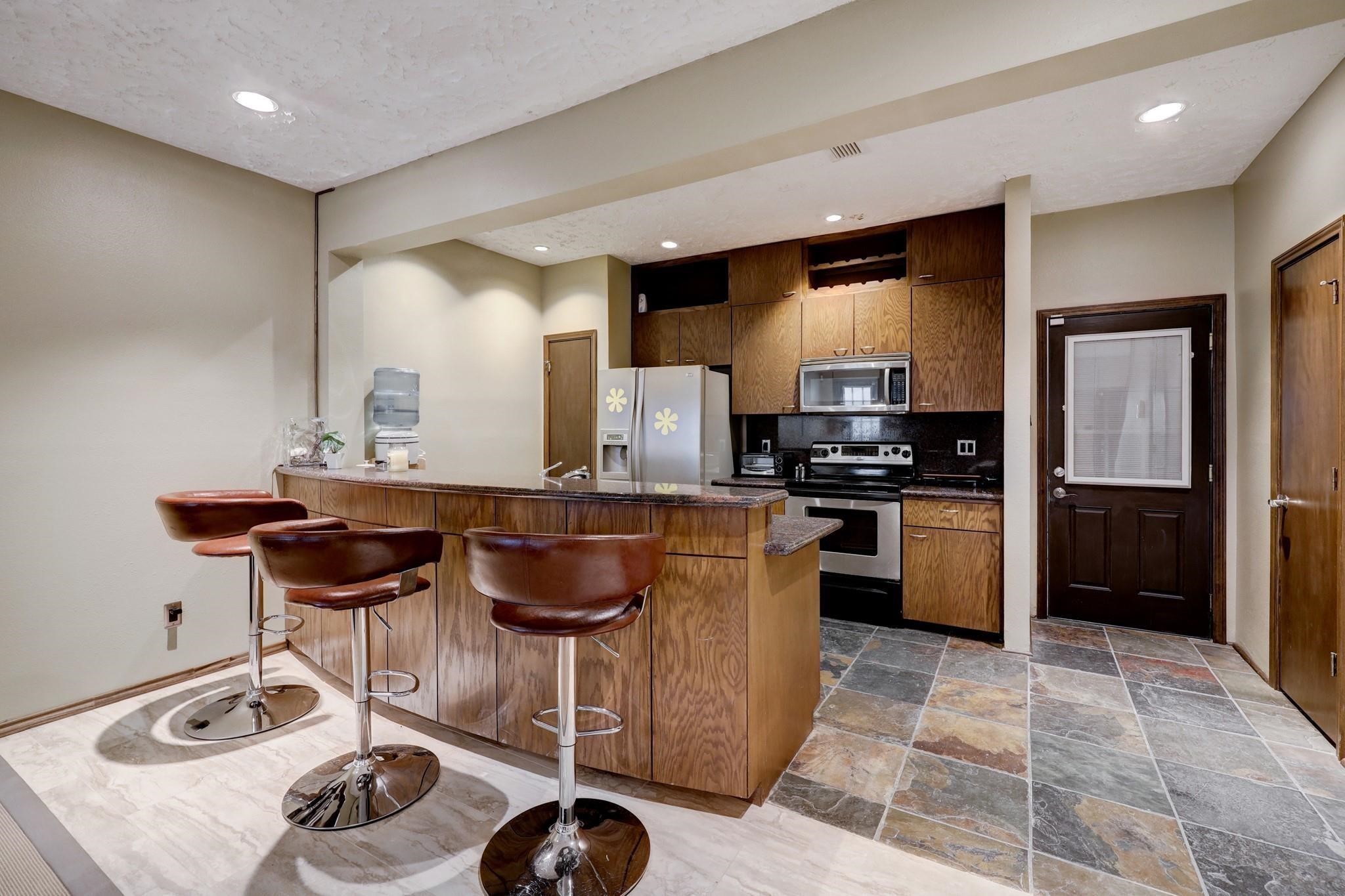 3198 Holly Hall Street, Unit 3198 Houston, TX 77054 - Photo 4 of 9 a kitchen with granite countertop a sink stainless steel appliances and cabinets