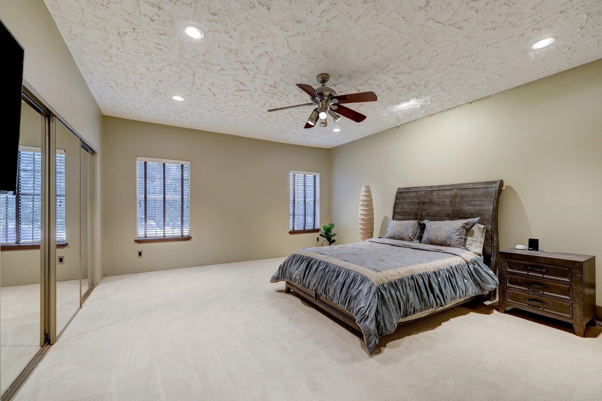 3198 Holly Hall Street, Unit 3198 Houston, TX 77054 - Photo 5 of 9 a spacious bedroom with a bed and a chandelier