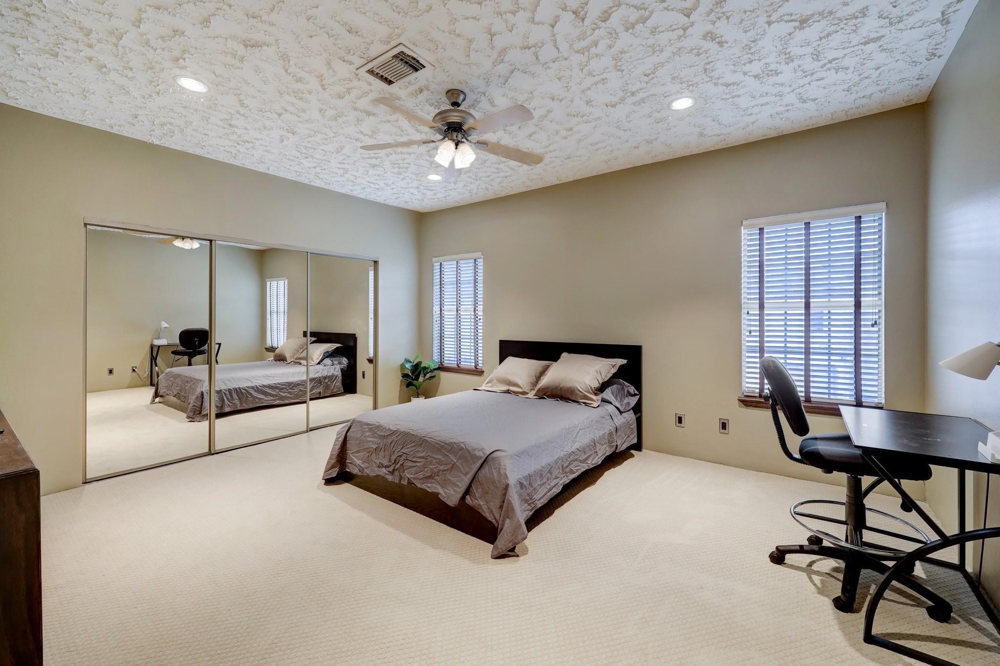 3198 Holly Hall Street, Unit 3198 Houston, TX 77054 - Photo 7 of 9 a spacious bedroom with a bed and a chandelier
