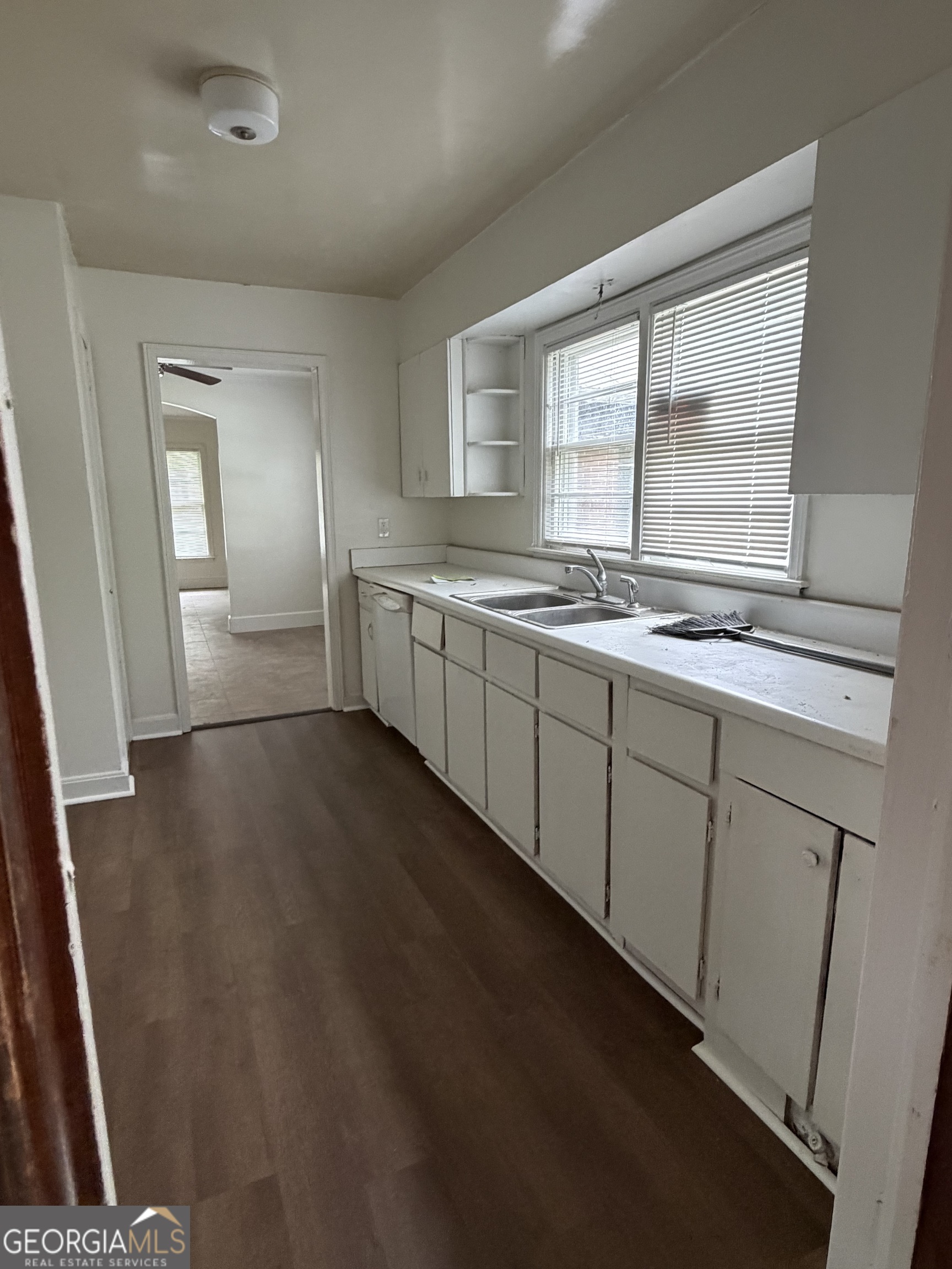 225 West Jessamine Street Fitzgerald, GA 31750 - Photo 16 of 39 a view of a kitchen with sink and dishwasher with wooden floor