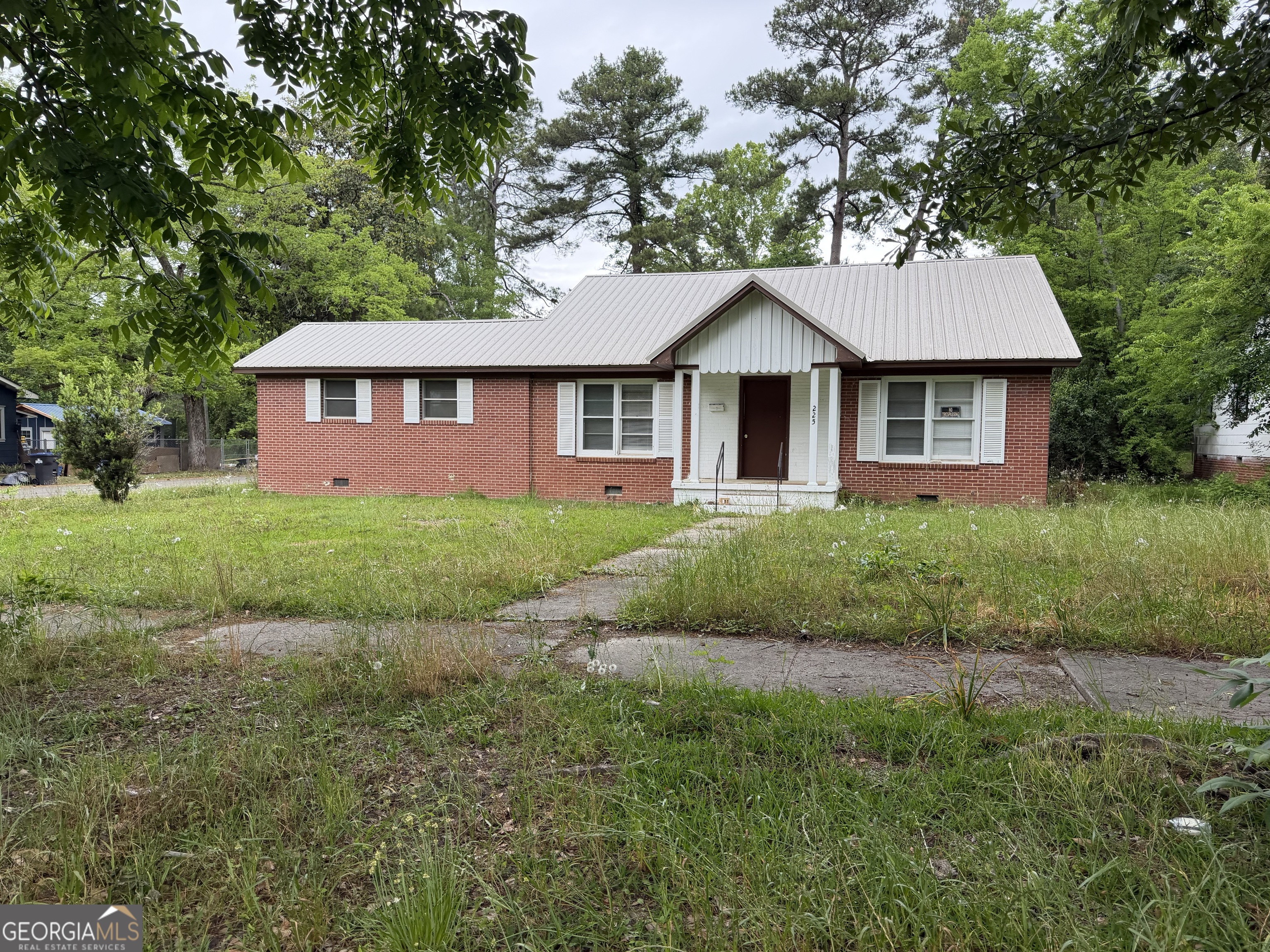 225 West Jessamine Street Fitzgerald, GA 31750 - Photo 3 of 39 a front view of a house with a yard and garage