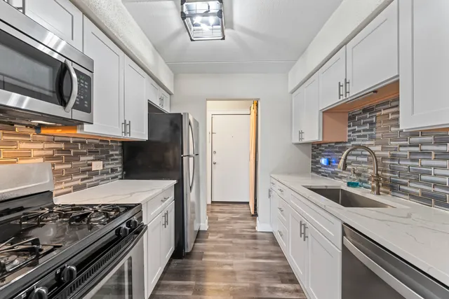 a kitchen with stainless steel appliances a sink stove and refrigerator