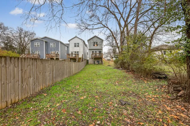 a view of house with garden and tall trees