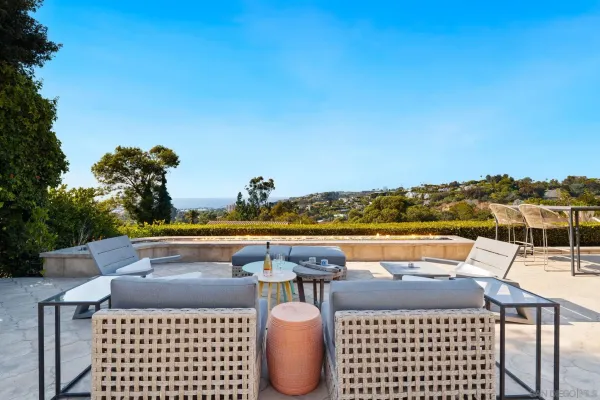 a view of a dining room and livingroom with furniture wooden floor a chandelier